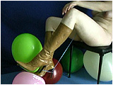 Heather uses her high heeled boots to foot pop balloons