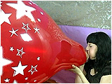 Video clip for sale of Heather blowing to burst a 24-inch Qualatex star print balloon