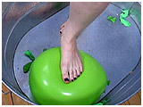 Xev footpops a big tub of balloons barefoot