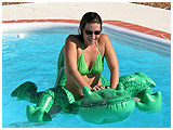 Christine plays with a blow up aligator in the pool