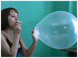 Adele exhales smoke into a clear balloon